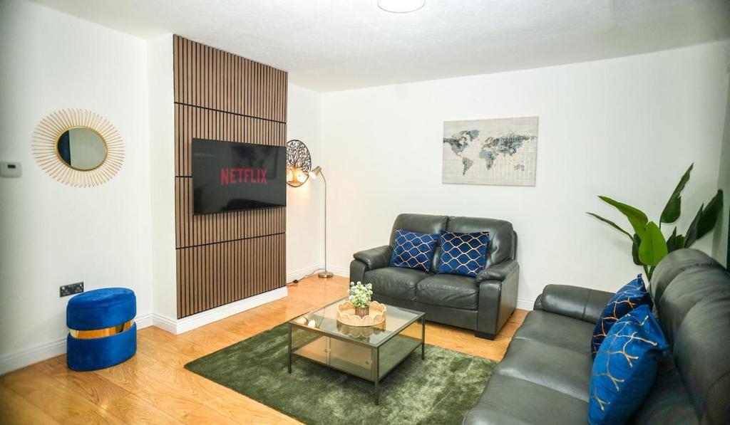 a living room with a couch and a table at Windsor and Heathrow Stay Comfort & Free Parking in Slough