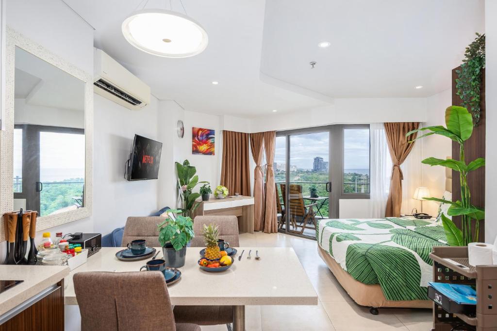 a living room with a bed and a table in a room at Dominiks Comfort and silent Studio Tambuli Balcony Pool Mactan Ocean View High Floor in Lapu Lapu City