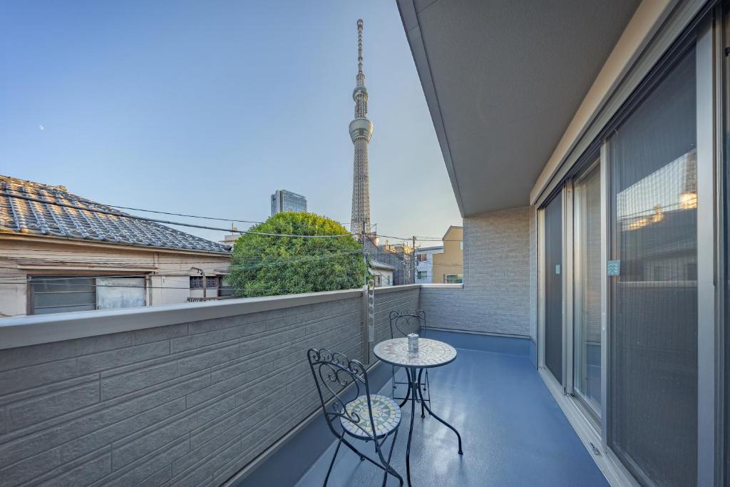 a balcony with two chairs and a table on it at Skytree House Oshiage New 3-story Villa, 2 Showers, 2 Toilets, 4 Rooms, 3 min walk to Oshiage Station in Tokyo