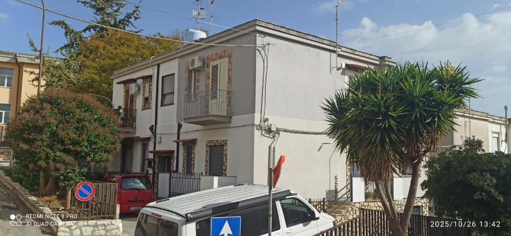 a white house with a car parked in front of it at Appartamento Bisa Queen in Bisacquino