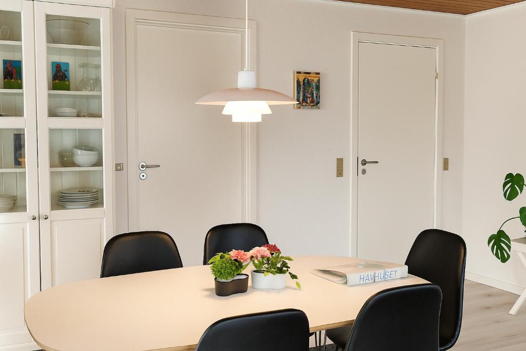 Un comedor blanco con una mesa y sillas. en Havhuset I Øster Hurup - i byen, ved stranden, en Øster Hurup