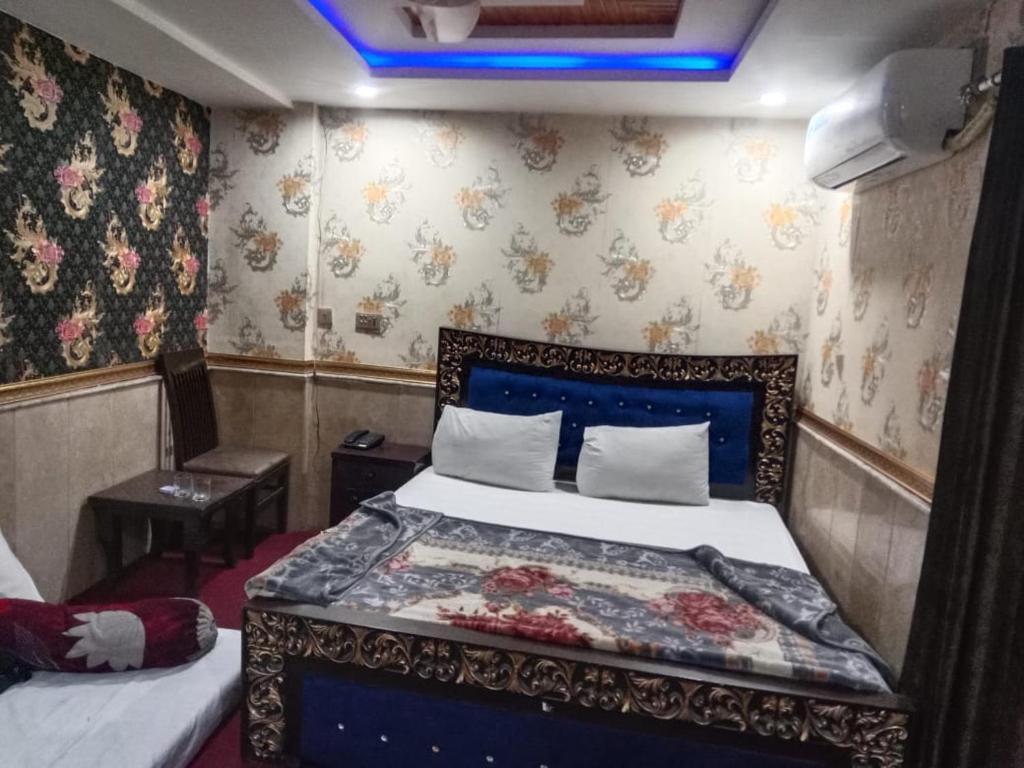 1 dormitorio con 1 cama en una habitación con papel pintado en Hotel The Shalimar, en Lahore