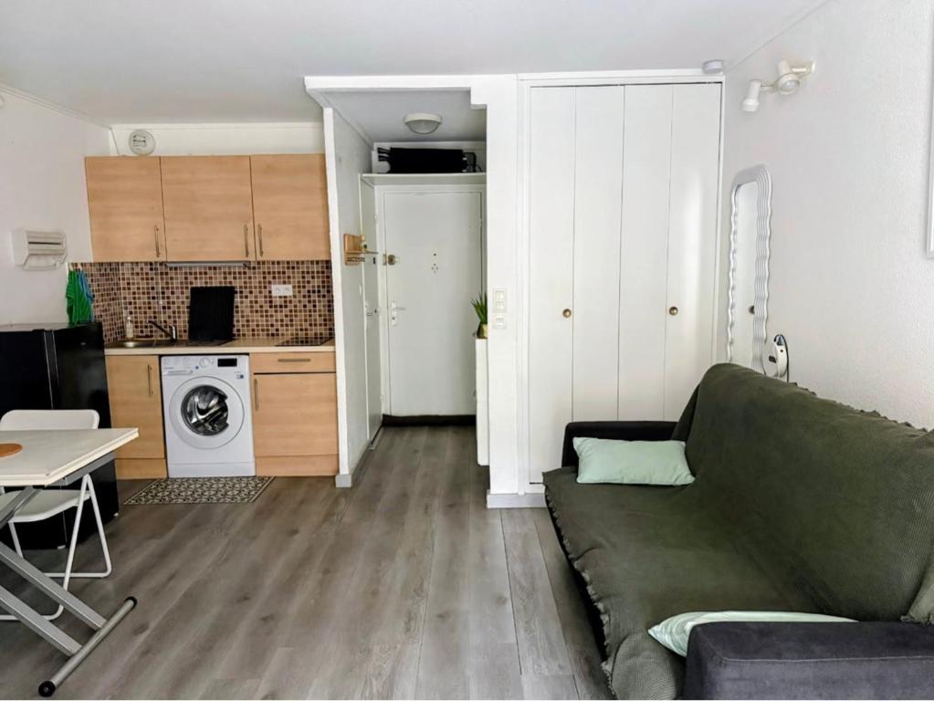 ein Wohnzimmer mit Sofa und eine Küche in der Unterkunft Studio cv 4p, parking privée cosy design in La Grande-Motte