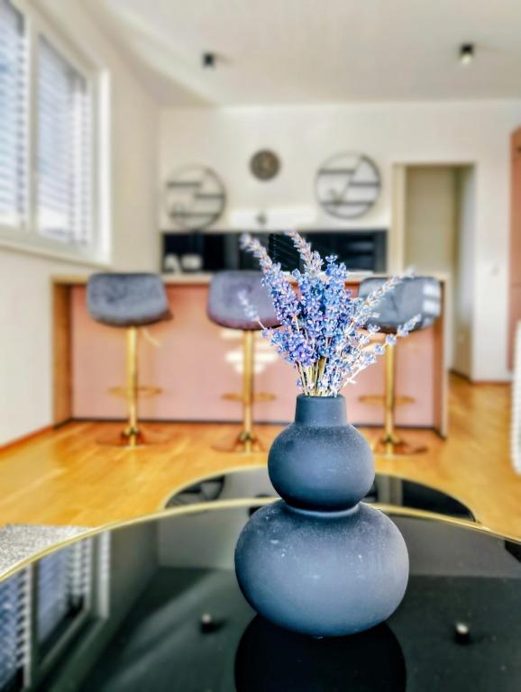 a blue vase with flowers sitting on top of a table at Apartments Ana in Maribor