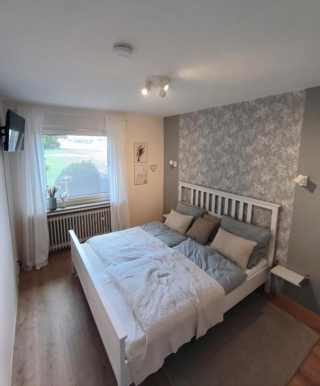 a large bed in a bedroom with a window at Ferienwohnung Waldgeflüster in Melle