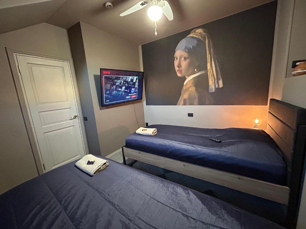 a bedroom with two beds and a painting on the wall at Traditional Narva House in Narva