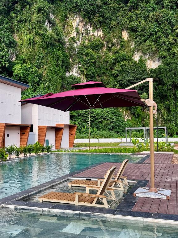 a group of chairs and an umbrella in a pool at Tambuna Retreat ,TAMBUN ,IPOH in Tambun