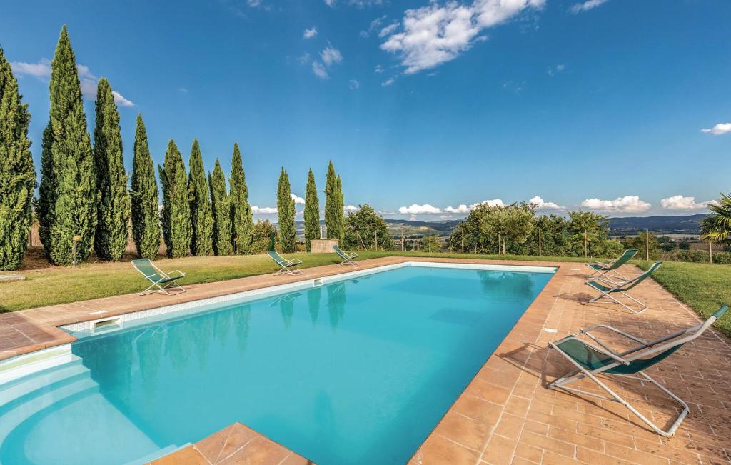 a swimming pool with two chairs and trees at Seranna 3 in Papiano