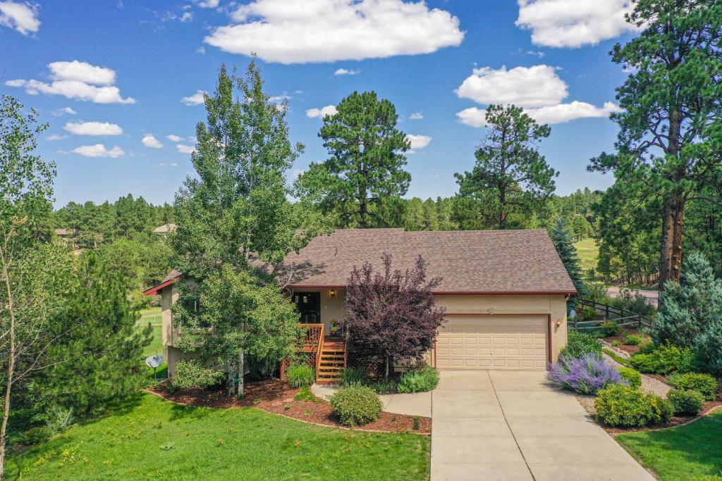 a house with a garage and trees at 120 Winding Meadow in Monument