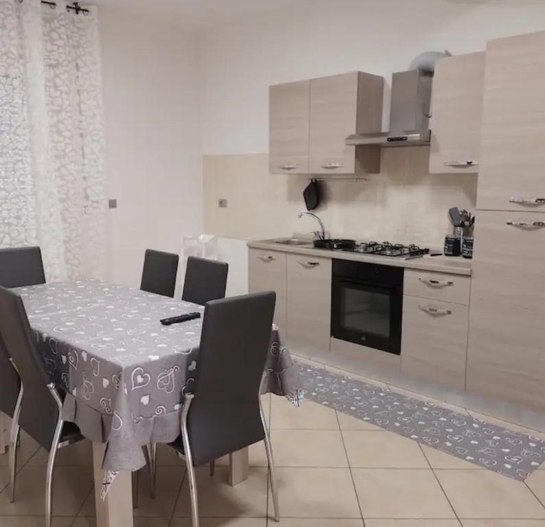 a kitchen with a table and chairs and a kitchen with a stove at La tartaruga in Montesilvano