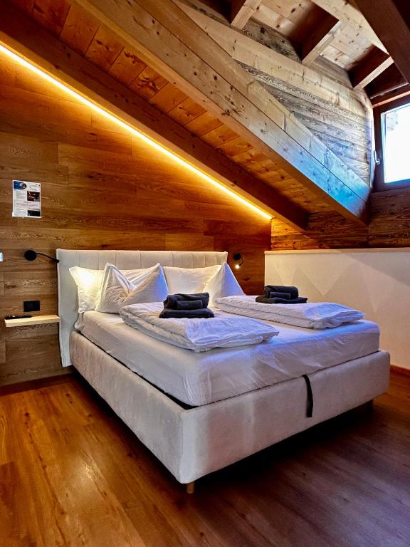 a large bed in a room with a wooden ceiling at Casa Franz in Tesero