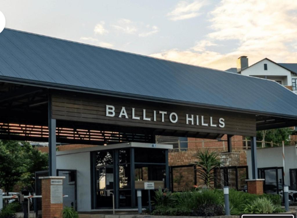 a building with a black roof with the words ballota hills at 832 Villa in Ballito