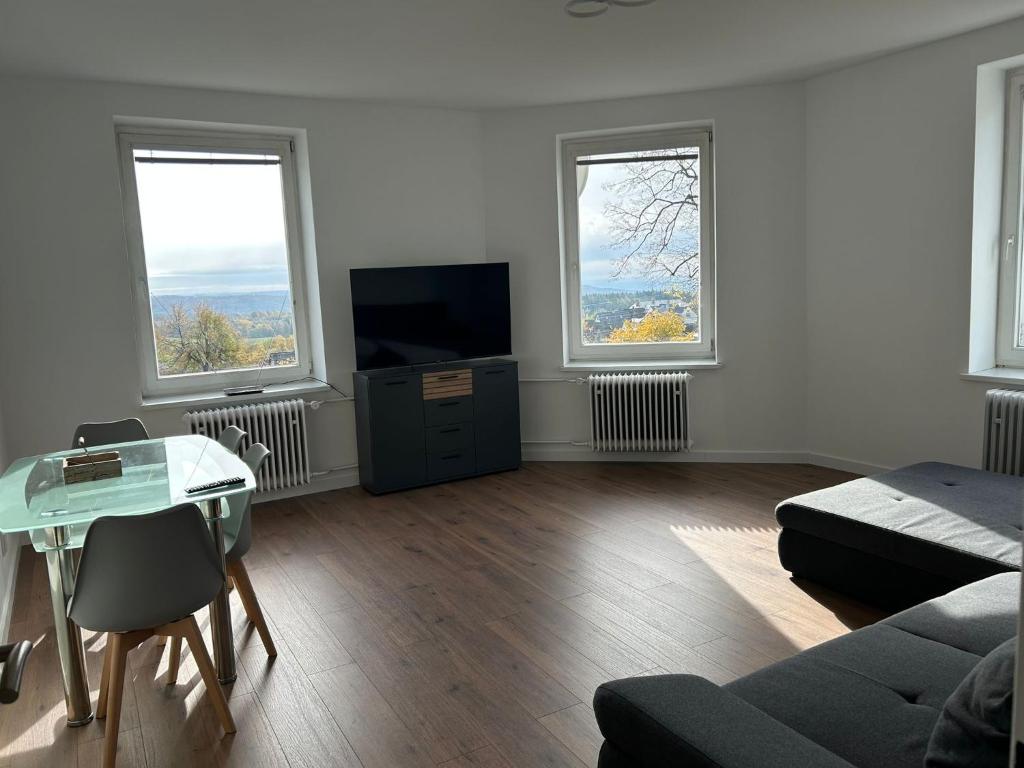 a living room with a tv and two windows at Apartmán 28 in Horní Město