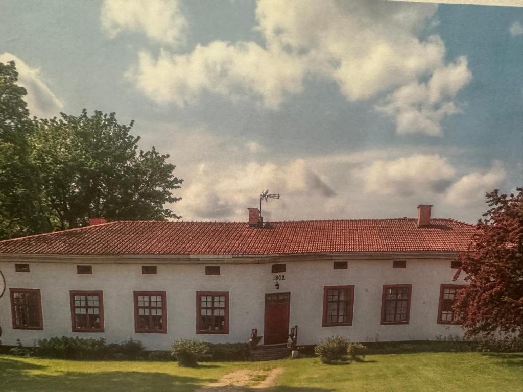 a large white house with a red roof at 2 rok i Söderfors wärdshus in Söderfors