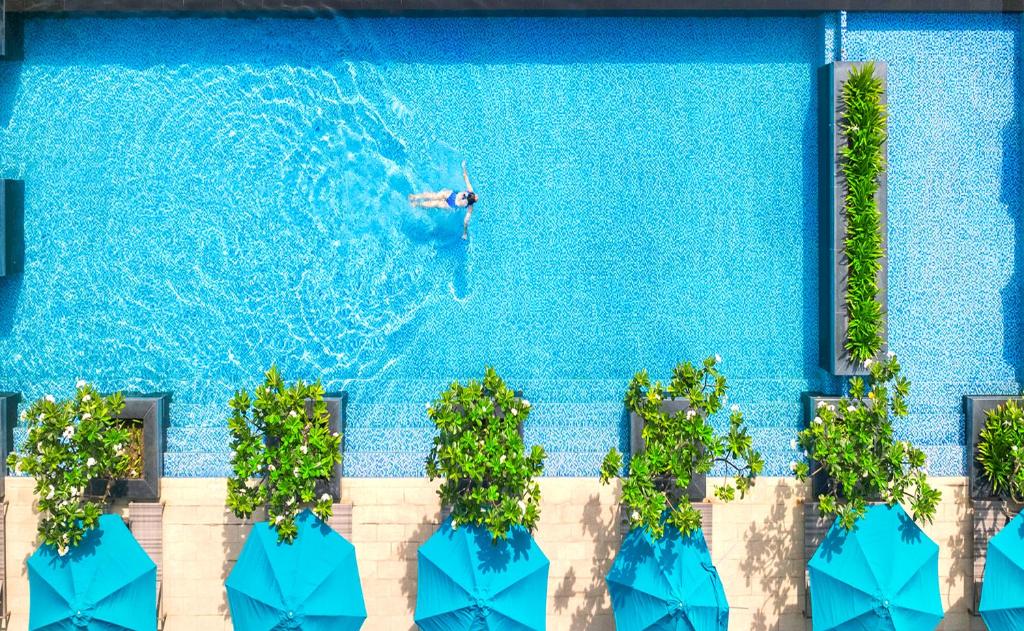 a man is swimming in a swimming pool at SUNNY - Resort Villas & City Apartments in Nha Trang