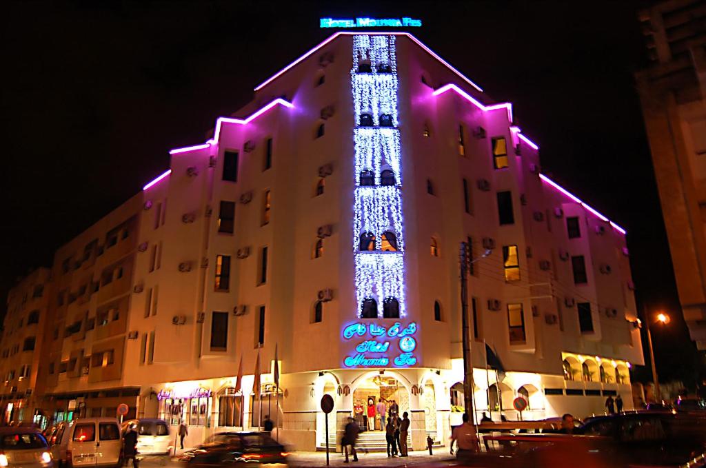 Um edifício com uma árvore de Natal ao lado. em Hotel Mounia em Fez