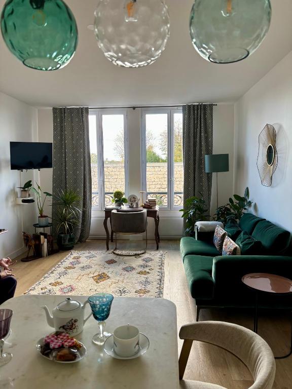 a living room with a green couch and a table at Cocoon Retreat in Chantilly