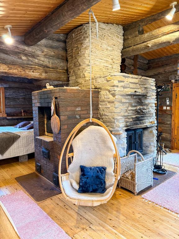 a room with a stone fireplace and a swing at Cabin bear's hide in Rovaniemi