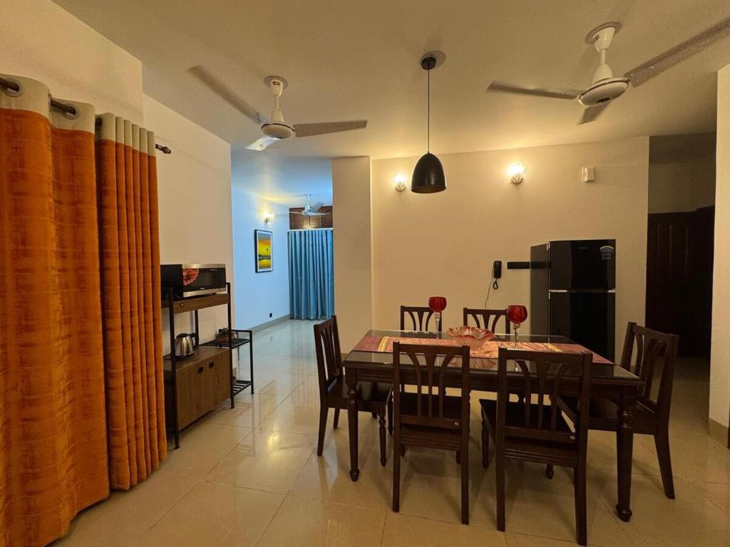 eine Küche und ein Esszimmer mit Tisch und Stühlen in der Unterkunft Maa in Dhaka