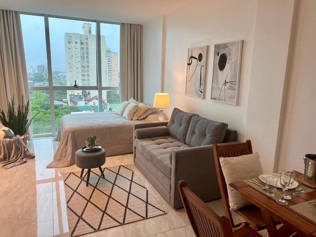 a living room with a bed and a couch at Charlotte Belgrano Posadas in Posadas