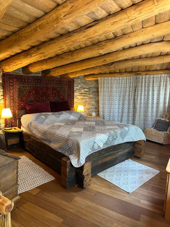 a bedroom with a large bed and a wooden ceiling at Casuta de lut in Sighişoara