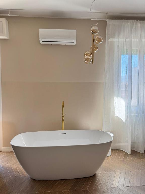 a white bath tub in a bathroom with a fan at EDA Home - Center & Cascata delle Marmore in Terni