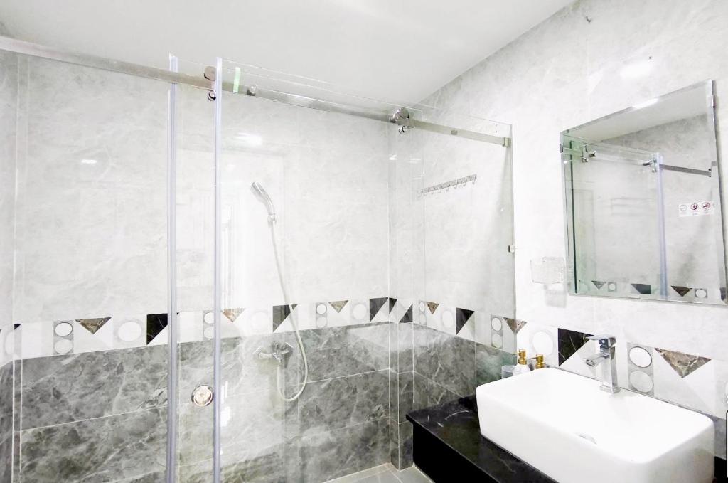 a bathroom with a shower and a sink and a sink at Kim's Studio District 1 in Ho Chi Minh City