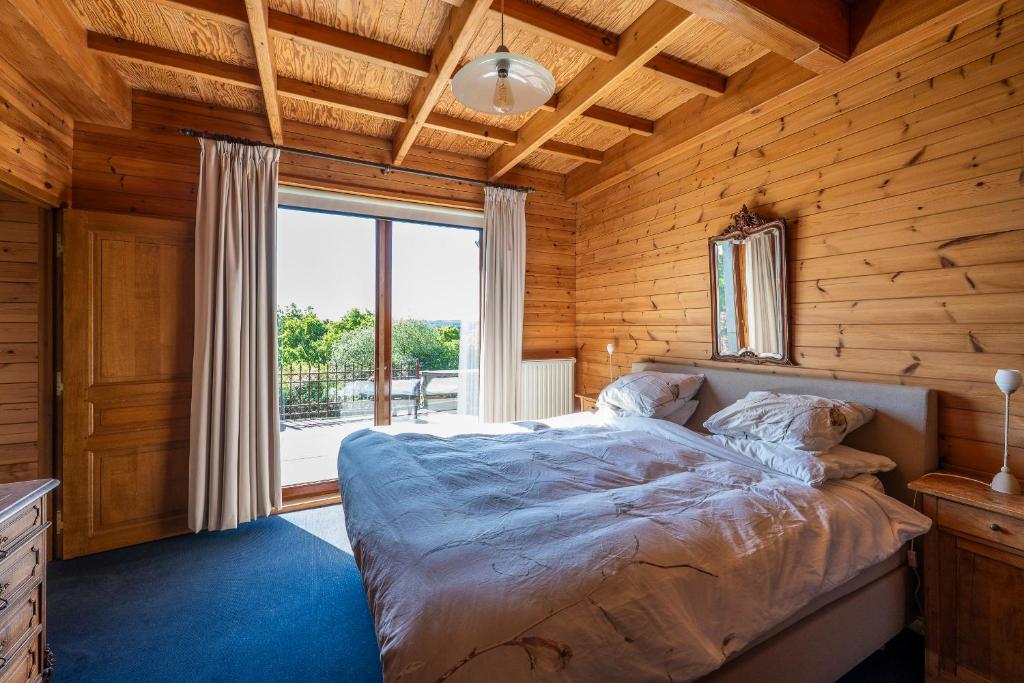a bedroom with a bed and a large window at Sous le Cielle d'Ardenne in La Roche-en-Ardenne