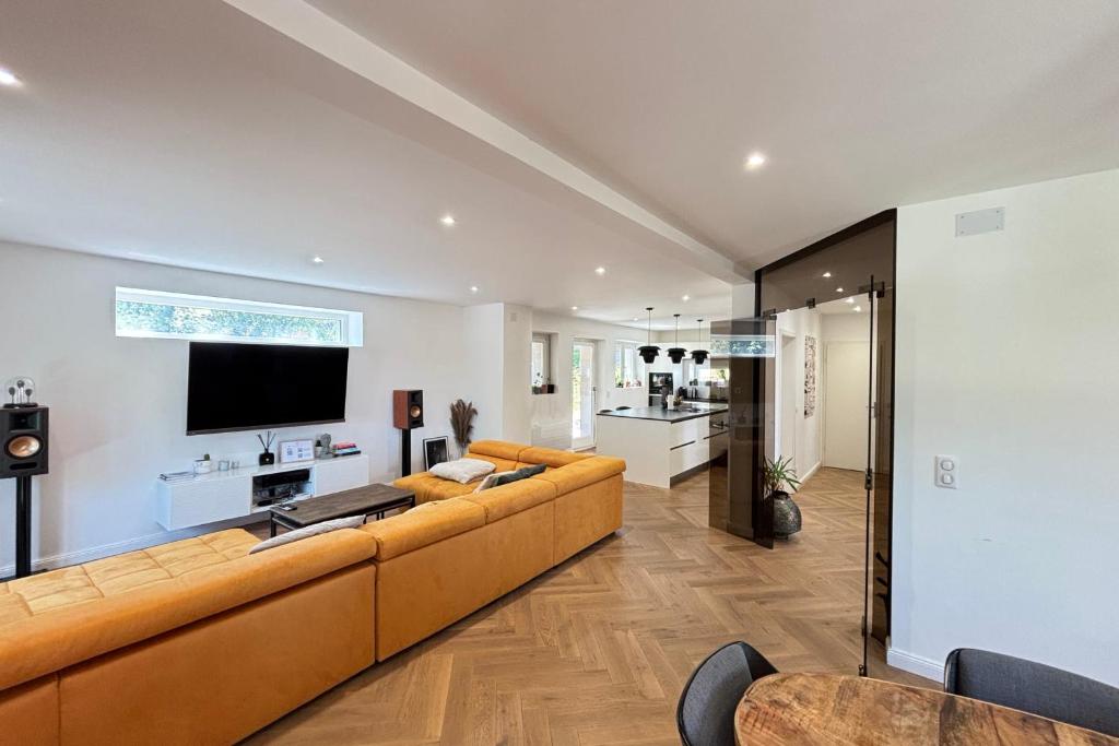 ein Wohnzimmer mit Sofa und Fernseher in der Unterkunft Soh Rent Maison - Villa Piscine Proche Strasbourg - TV - Wifi - Parking in Lampertheim