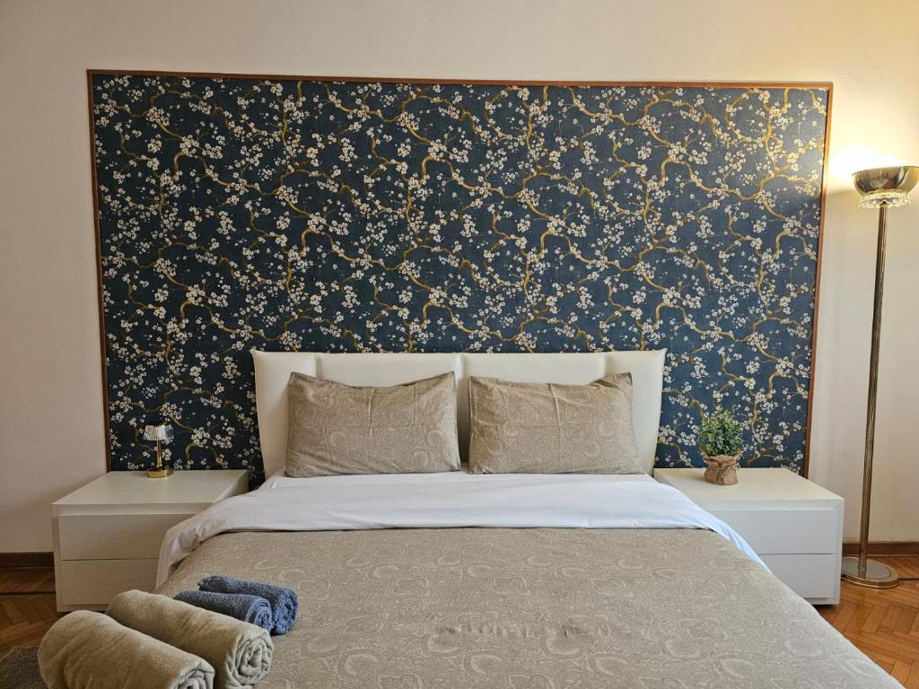 une chambre avec un lit avec un papier peint bleu et or dans l'établissement Dolce Vita Luxe Studio, à Venise