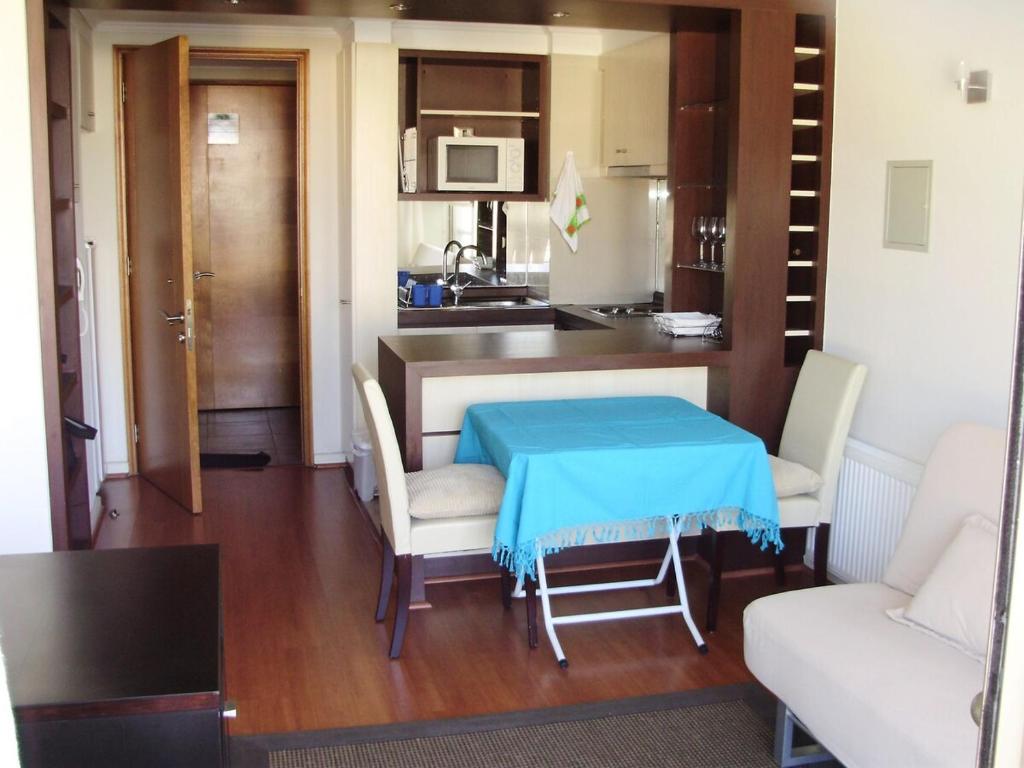 a small kitchen with a blue table and chairs at Departamento acogedor con excelente ubicación in El Cerrillo
