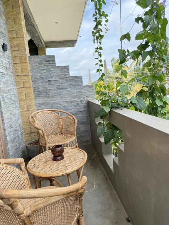 a patio with two chairs and a table and some plants at Olaia Apartments and Cafe in Weligama