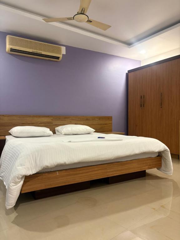 a bedroom with a bed and a ceiling fan at Zarica Homestay in Kannur