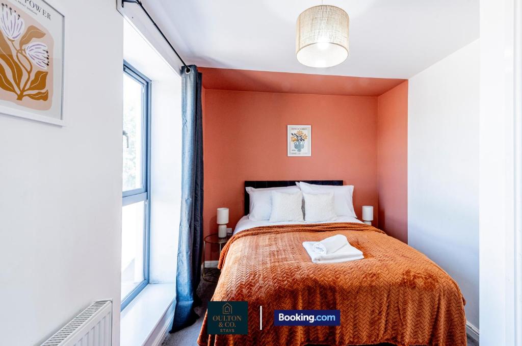Un dormitorio pequeño con paredes naranjas y una cama. en Luxury Retreat For 10 - Short Lets & Serviced Accommodation Manchester With Hot Tub and Spacious Garden, en Mánchester