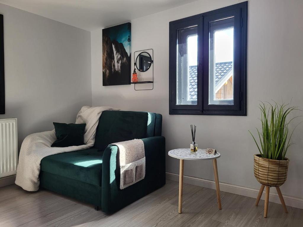 Una sala de estar con un sofá verde y una mesa. en Căsuța Piticilor, en Broşteni