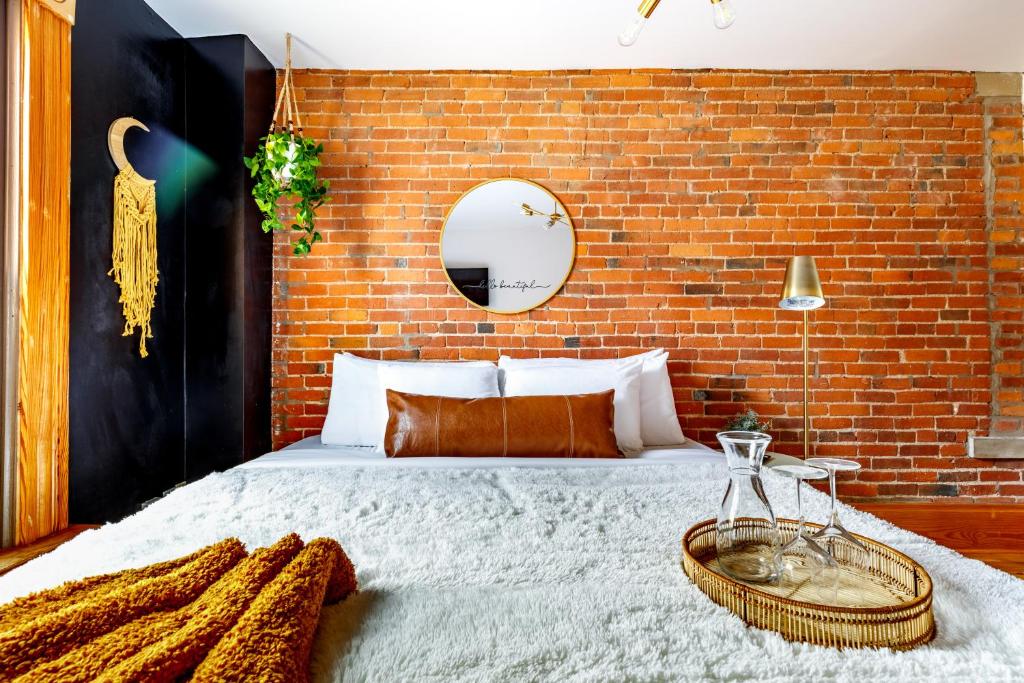 une chambre avec un grand lit avec un mur de briques dans l'établissement Prime Location Top Rated Clean Parking Free!, à Columbus