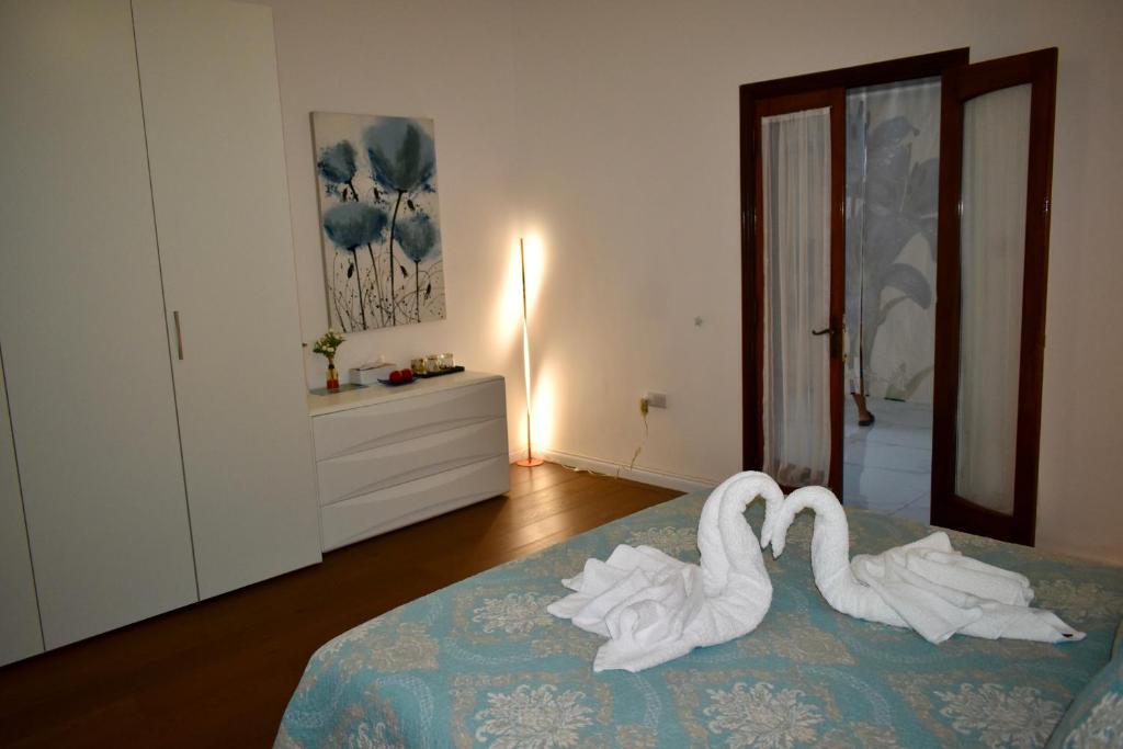 two white swans sitting on a bed in a bedroom at Secret Villa - Room Lily in Taʼ Lampuka