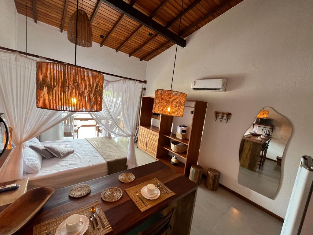 1 dormitorio con 1 cama, 1 mesa y 2 luces en Estúdio com piscina, en Trancoso