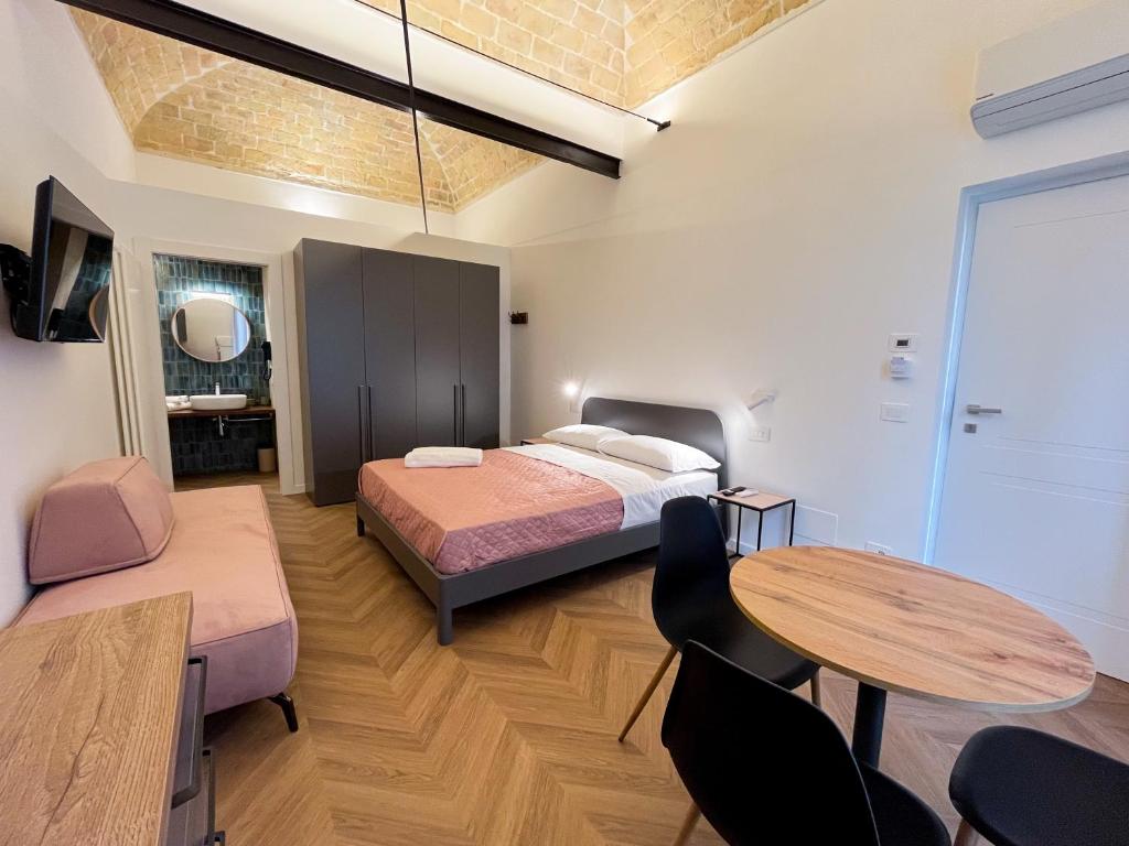 a bedroom with a bed and a table and chairs at Residenza Veneto 80 in Vasto
