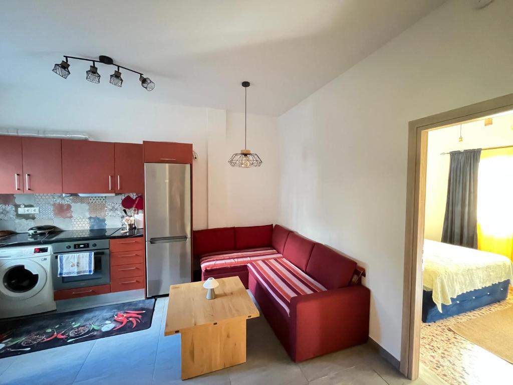 Una sala de estar con un sofá rojo y una mesa. en AA seaside apartment, en Artemida