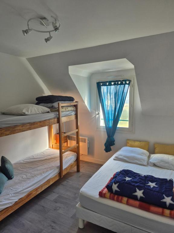 a bedroom with two bunk beds and a window at maison proche plage du pouliguen baie de la baule in Le Pouliguen