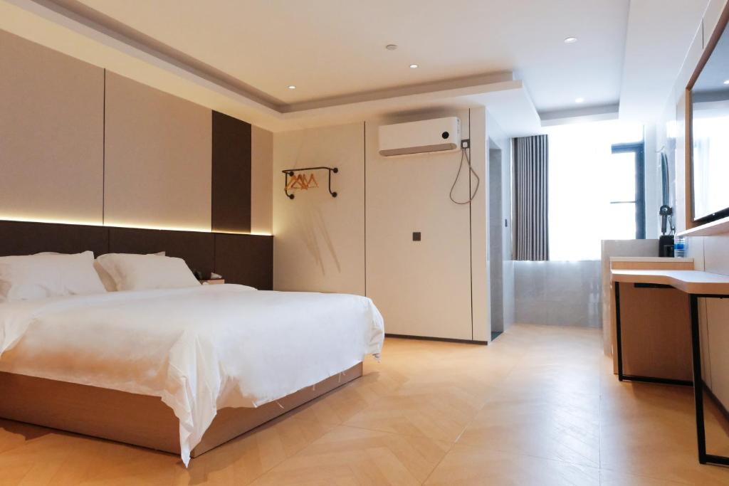 a bedroom with a large white bed and a desk at HuaHang Hotel - Free Shuttle&Free Breakfast - Guangzhou Baiyun International Airport in Guangzhou