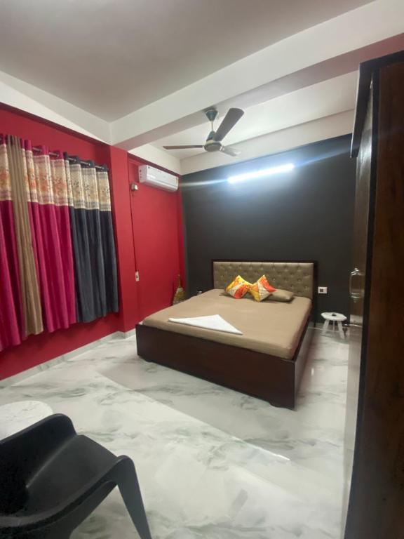 a bedroom with a bed and a red wall at Haven Stay in Dibrugarh
