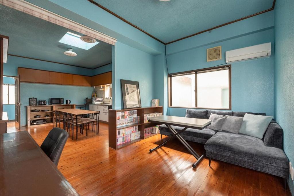a living room with a couch and a table at 一棟貸しハウスまれち in Kumejima