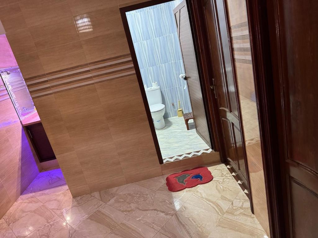 ein Badezimmer mit Toilette und Spiegel in der Unterkunft Maison familiale 2 chambres salon marocain in Tiznit