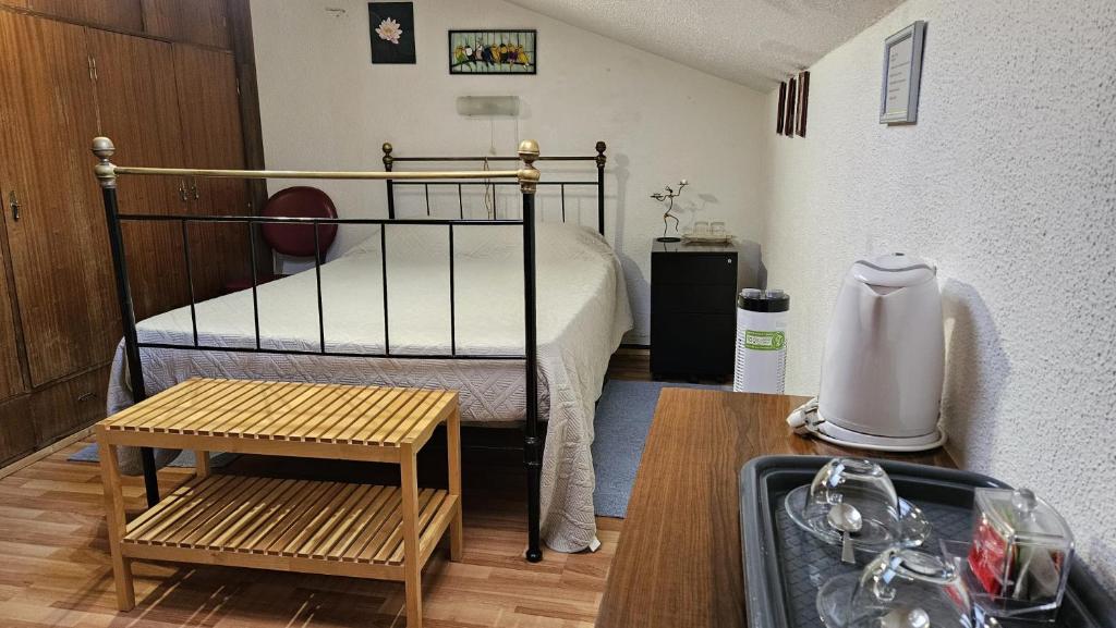 ein kleines Schlafzimmer mit einem Bett und einem Tisch in der Unterkunft Suite Porto in Porto