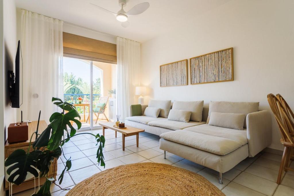 a living room with a couch and a plant at Mediterranean Dream by the Sea in Paphos City