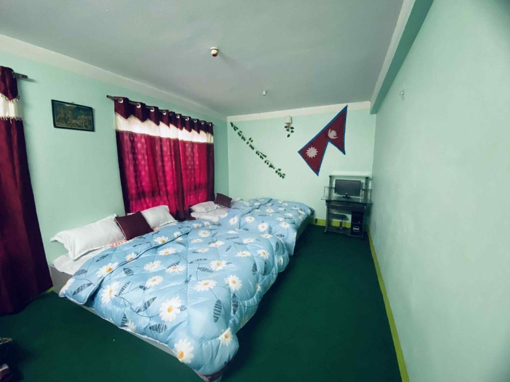 a bedroom with a large bed with a blue comforter at Homemade guest house and netflix in Bhaktapur