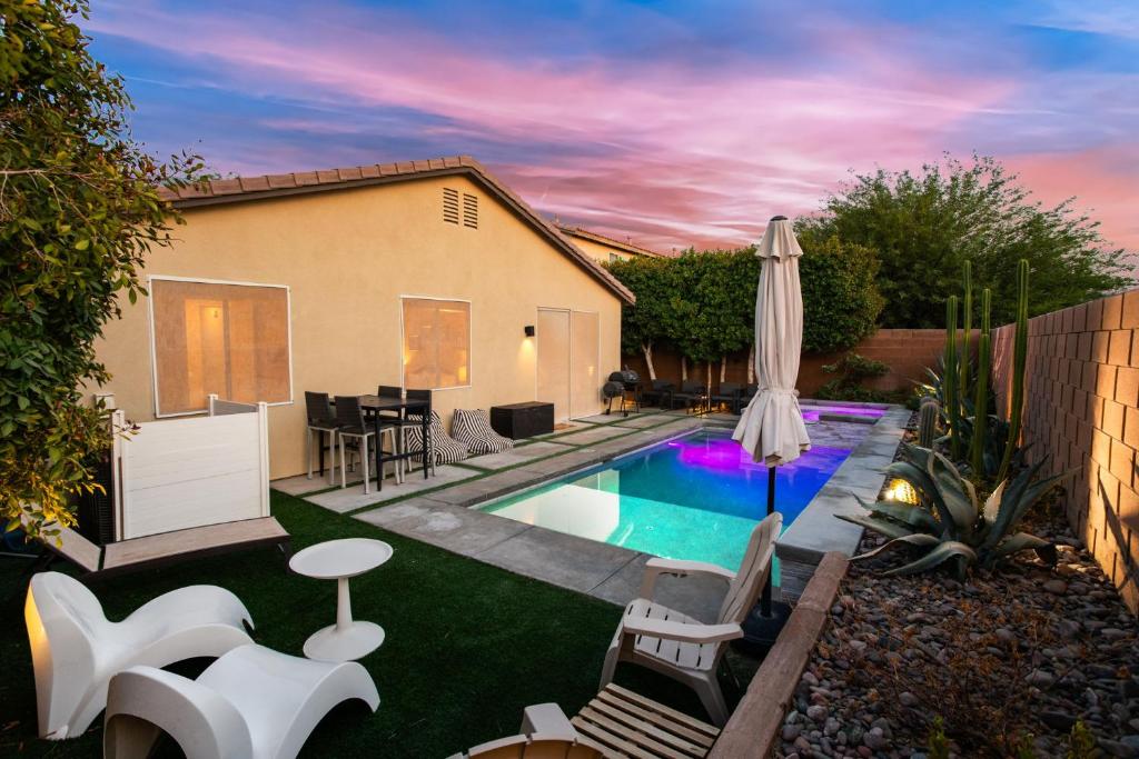 a backyard with a swimming pool and an umbrella at Walk to the Festivals - Private Pool & Spa in Indio