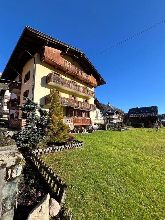 a large building with a green field in front of it at Haus Piller Cottrer Pietro in Sappada